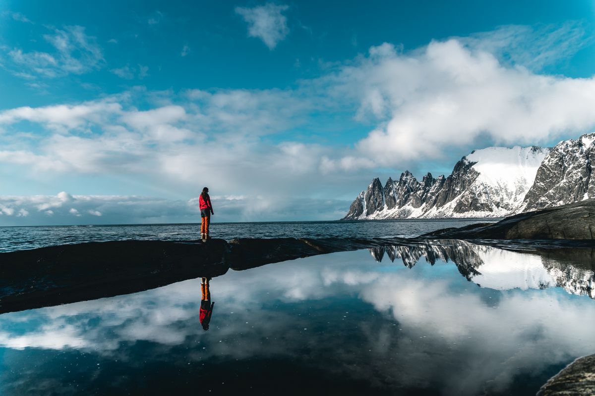 A person standing beside a mountain lake