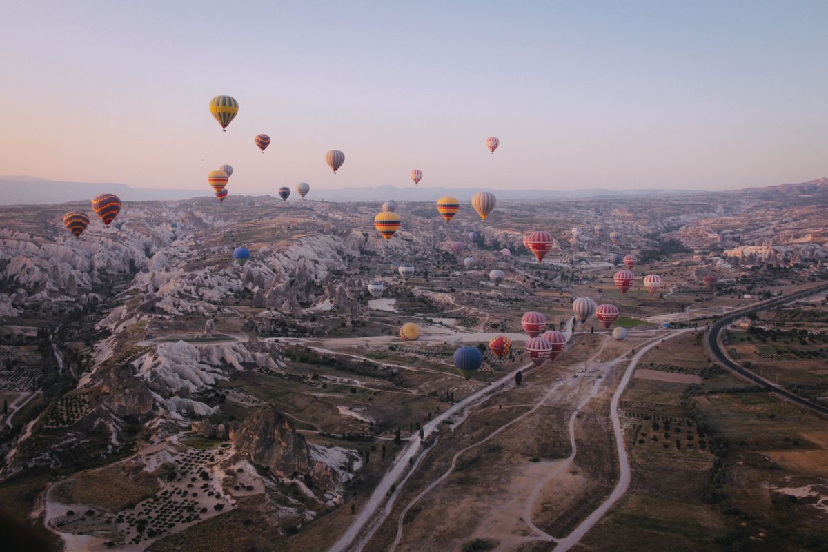 Hot-air balloons above a rocky landscape